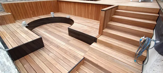 Banquette arrondie encastrée dans une terrasse en bois