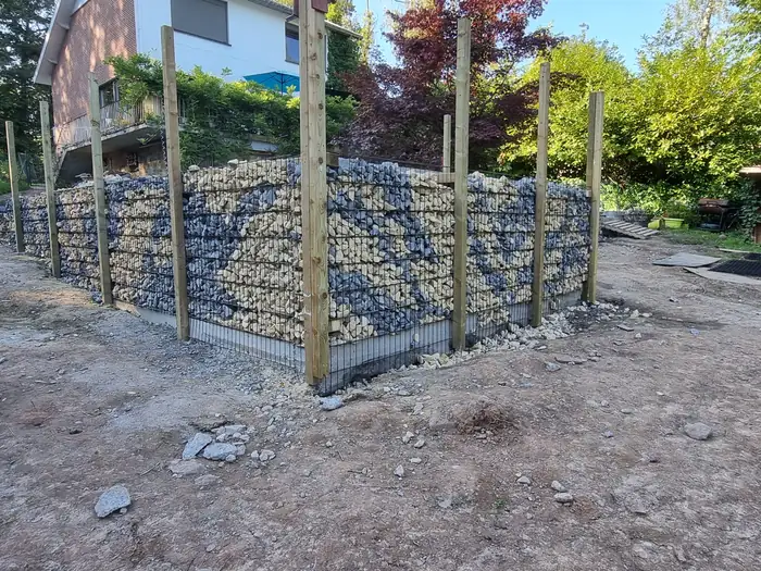 Mur de gabions en construction, cages acier remplies de pierre