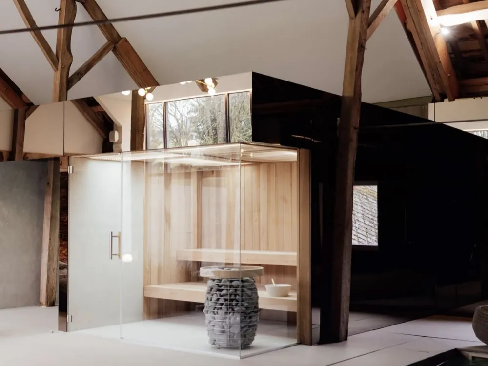 Ensemble wellness sur mesure conçu par Sebonard : sauna vitré sous charpente et bassin de nage