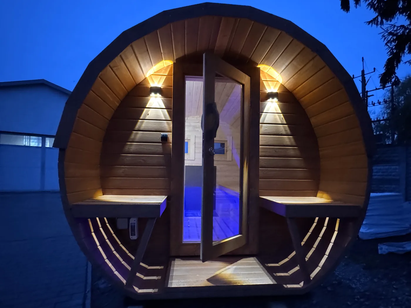 Sauna tonneau avec terrasse à la nuit tombée