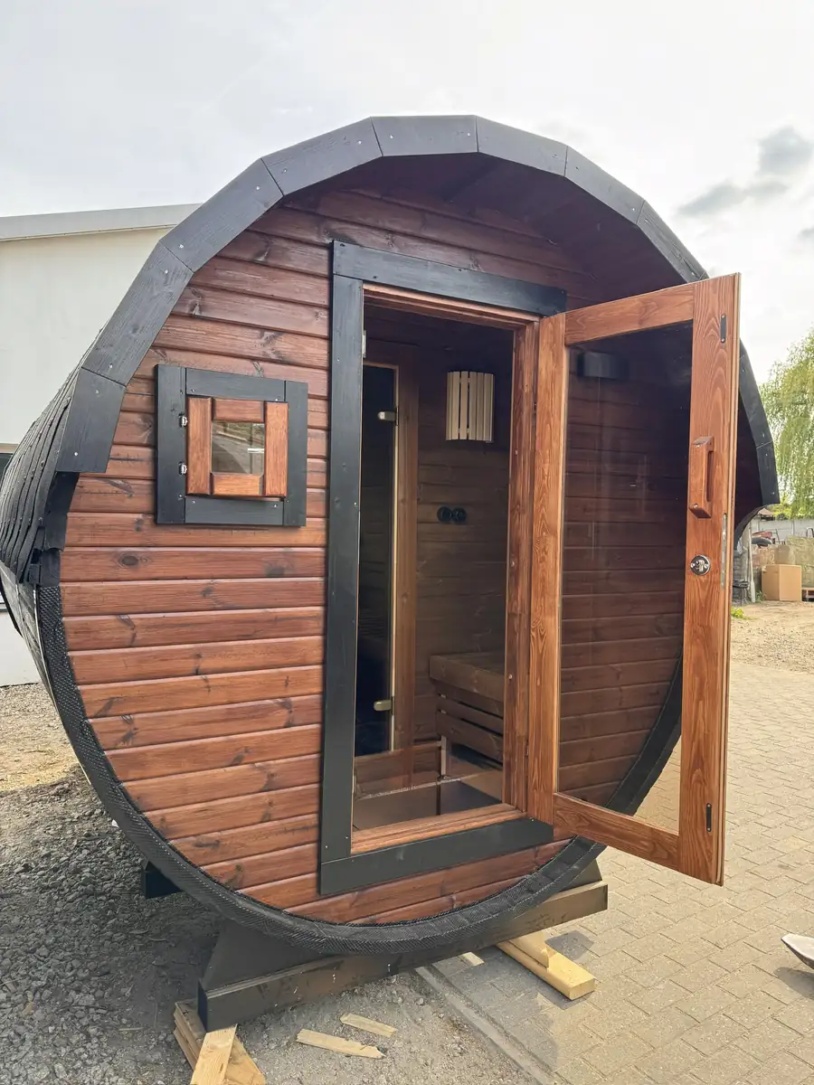 Sauna tonneau avec terrasse à la nuit tombée